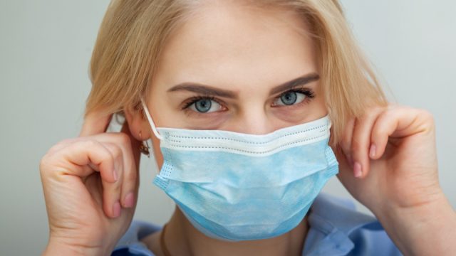 woman with a surgical mask on her face against SARS-cov-2.