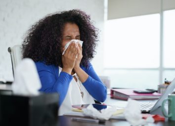 Sick woman working from home office.