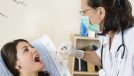 Young woman at doctor being tested for pain in the throat