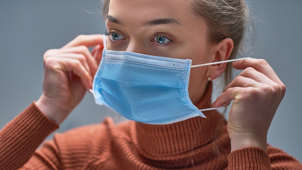 putting on medical protective mask to health protection and prevention during flu virus outbreak, epidemic and infectious diseases