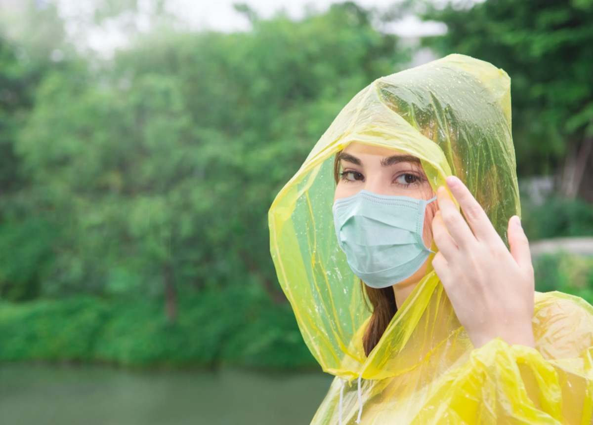 woman in yellow rainwear with mask for protection coronavirus.