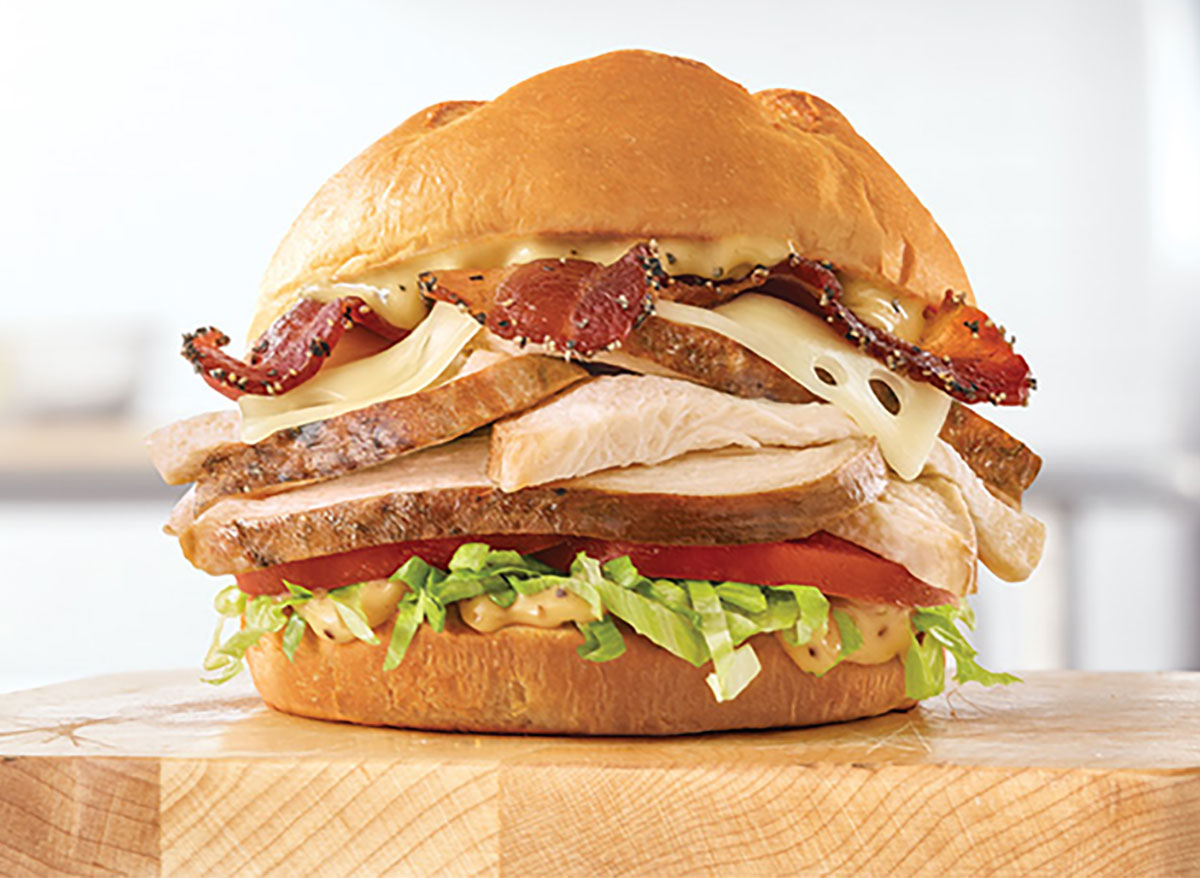 arbys roast chicken bacon and swiss sandwich on wooden board