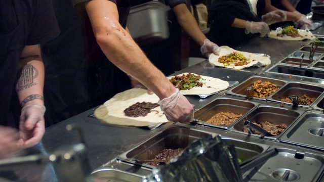 chipotle workers assembling burritos