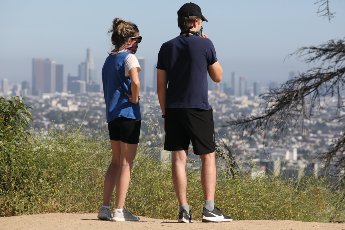 couple wearing masks due to corona virus pandemic at the Griffith Park in Los Angeles