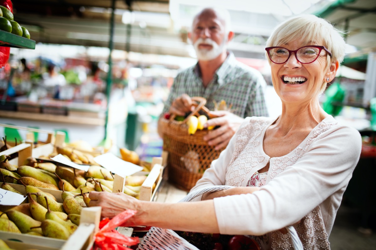 elderly couple in market buing food