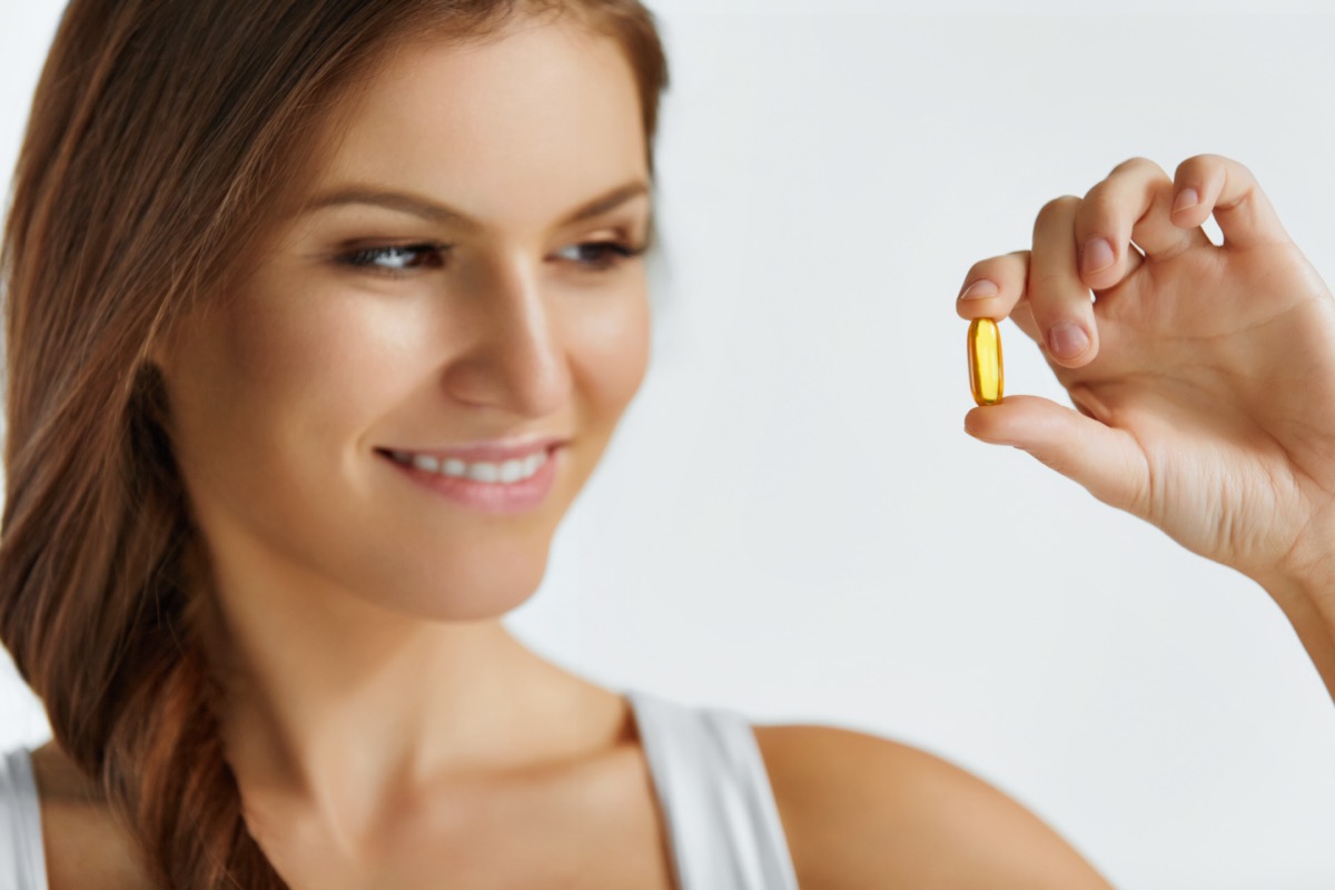 Happy Beautiful Girl With Pill With Cod Liver Oil Omega-3