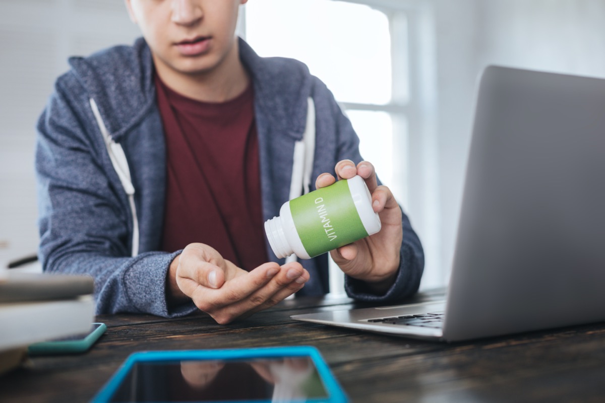 Man sitting at the table and taking vitamin D