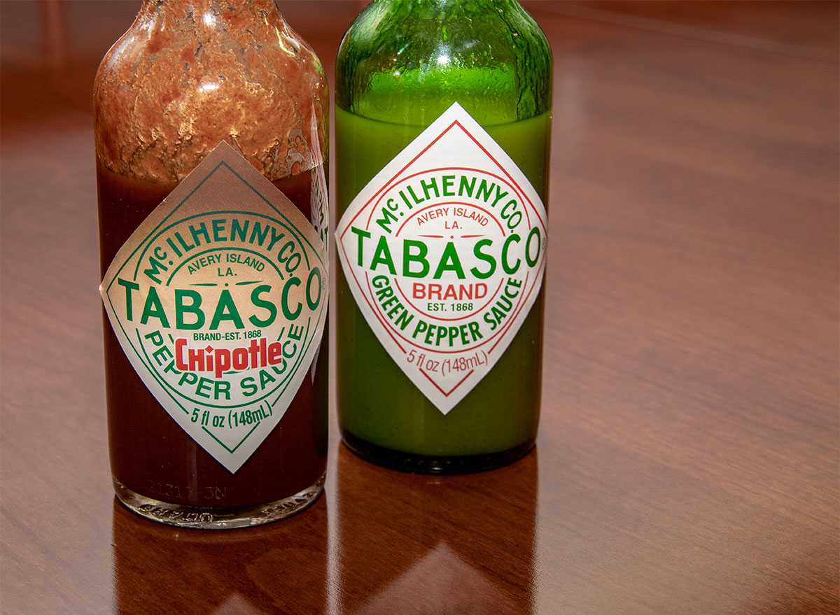 two bottles of tabasco sauce on a table