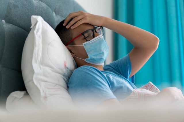 Teenager sick in bed with Covid-19 symptoms