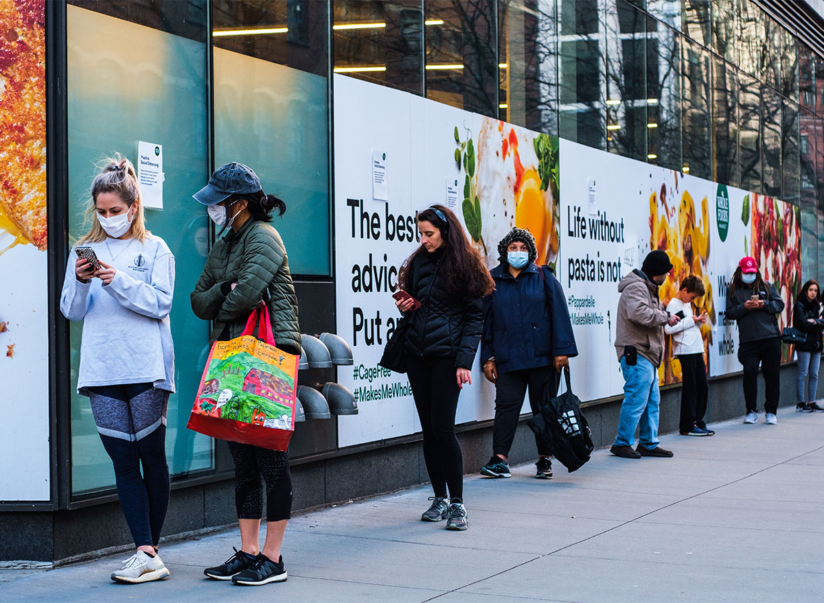 people wearing masks in line outside whole foods