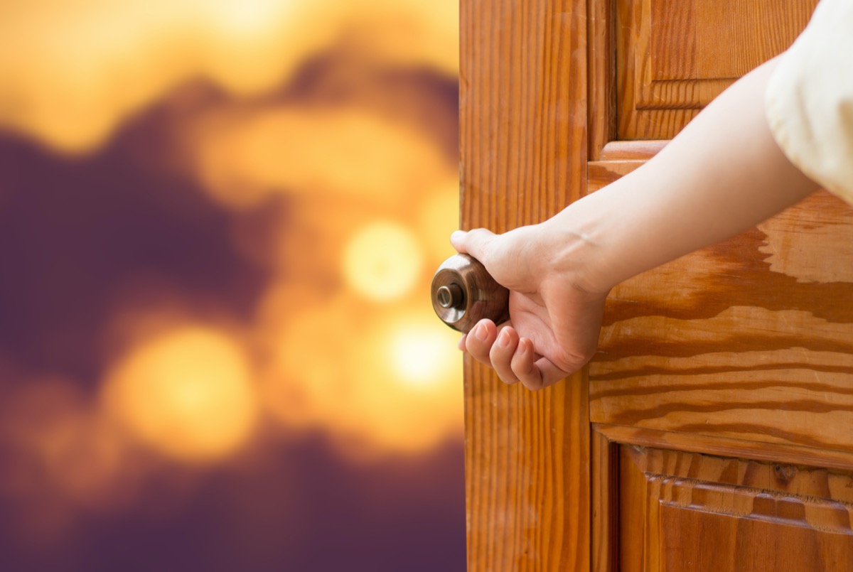 Women hand open door knob.