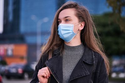 Woman wearing medical protective mask outdoors