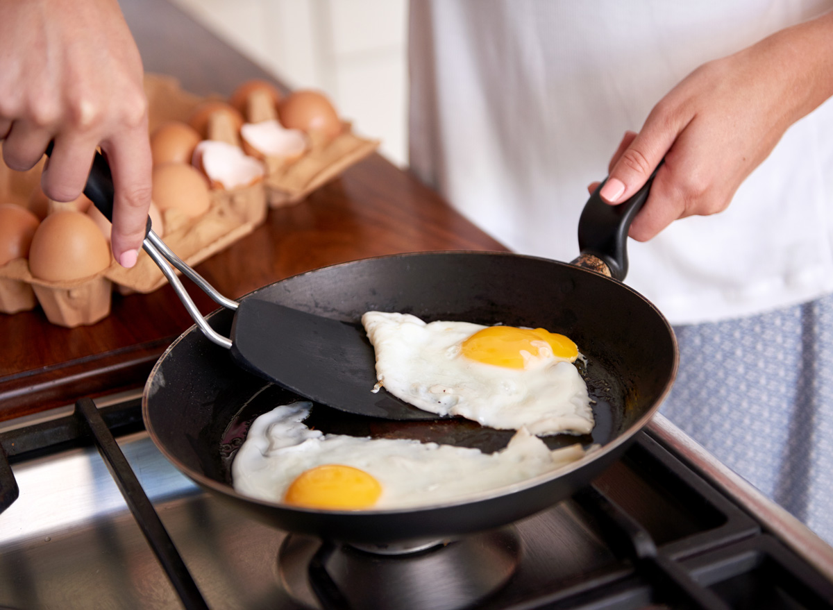 Woman frying fried egg yolk pan