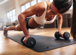 Woman with strong muscle arms doing push ups for exercise