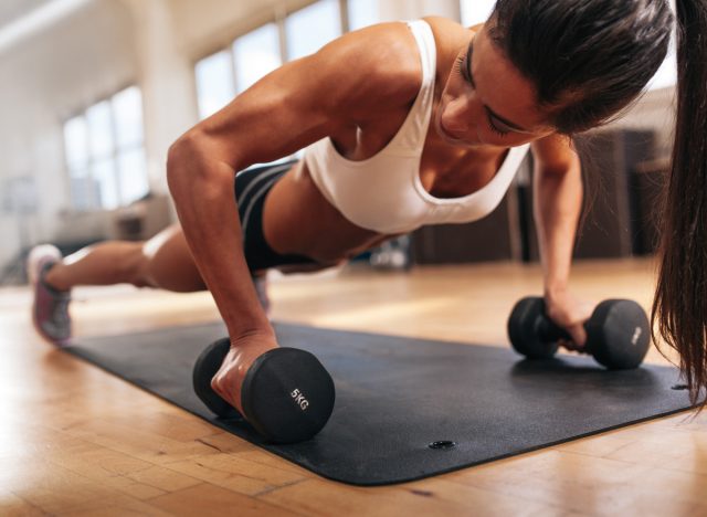 Woman with strong muscle arms doing push ups for exercise