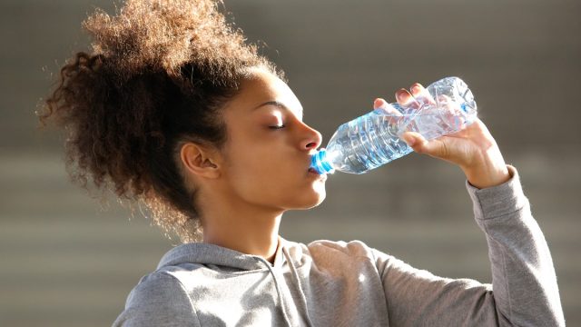 Black woman drinking bottled water