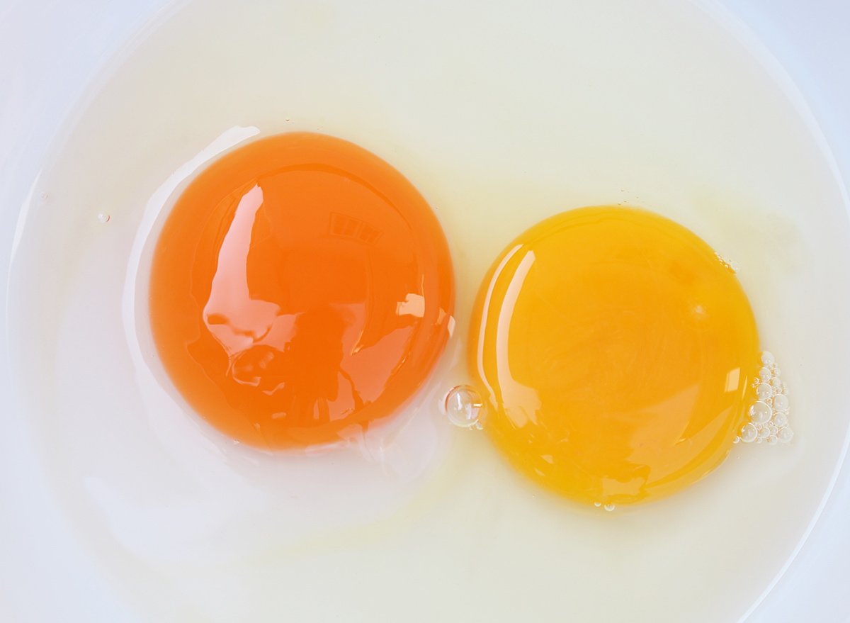 two different egg yolk colors in a bowl