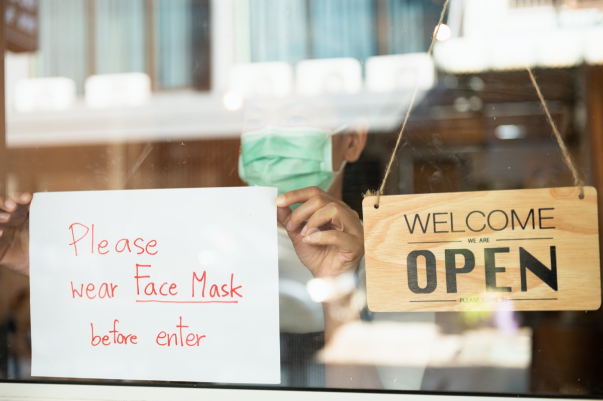 restaurant shop owner woman attaching request customer to wear face mask before enter