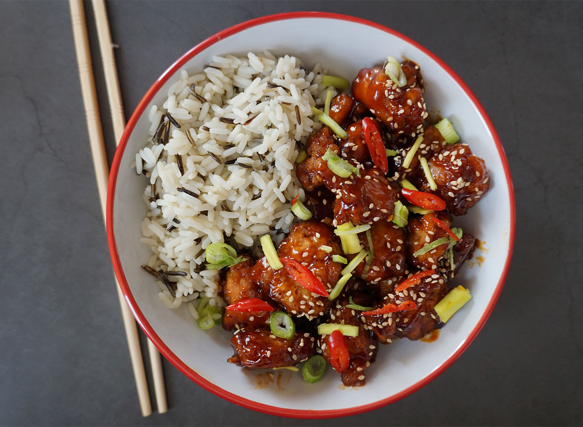 bowl of general tsos cauliflower with rice and chopsticks