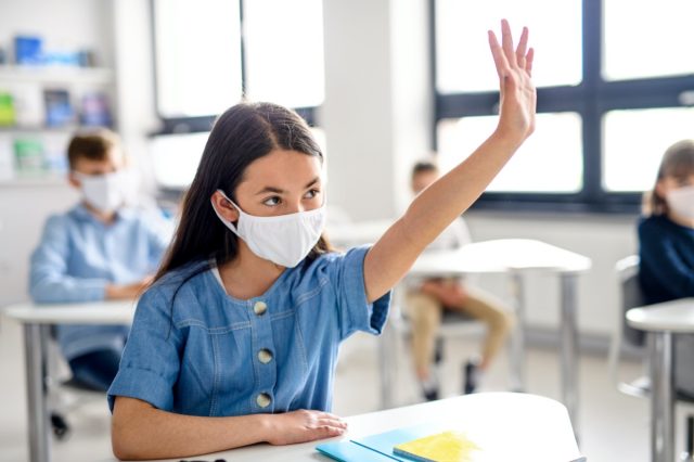 Girl with face mask back to school after quarantine and lock covid-19.