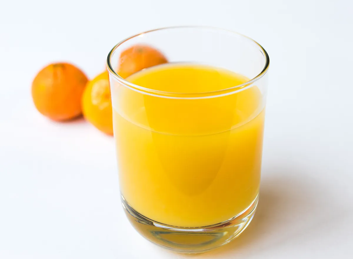 glass of orange juice with oranges