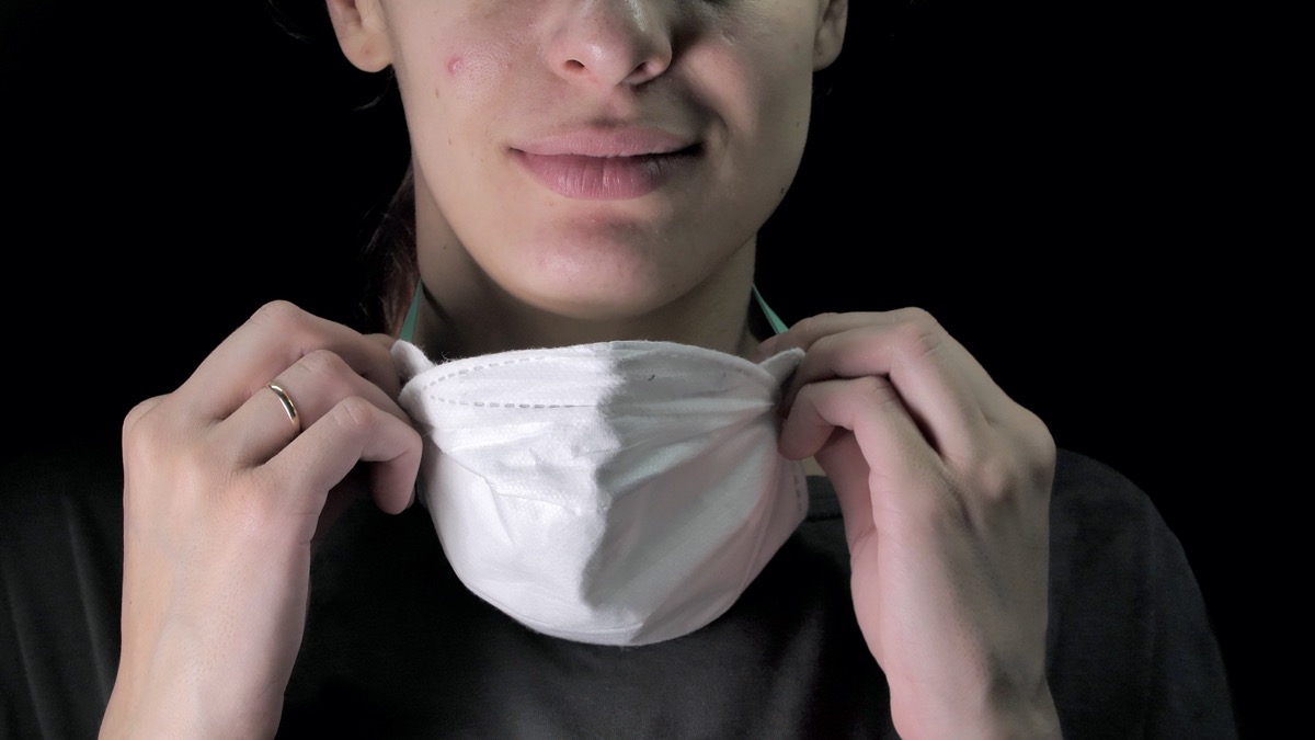 woman putting on or put off a medical protective mask