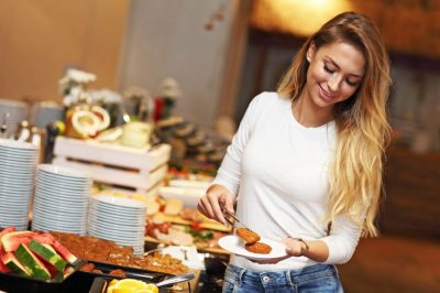 Picture of attractive woman at breakfast buffet in hotel