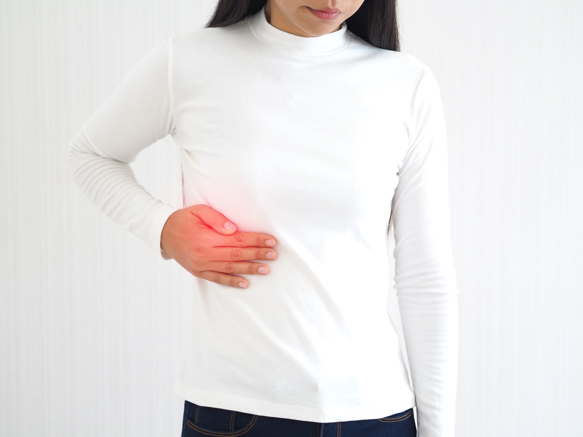 woman and she touching in the upper right portion of abdomen and above stomach symptoms