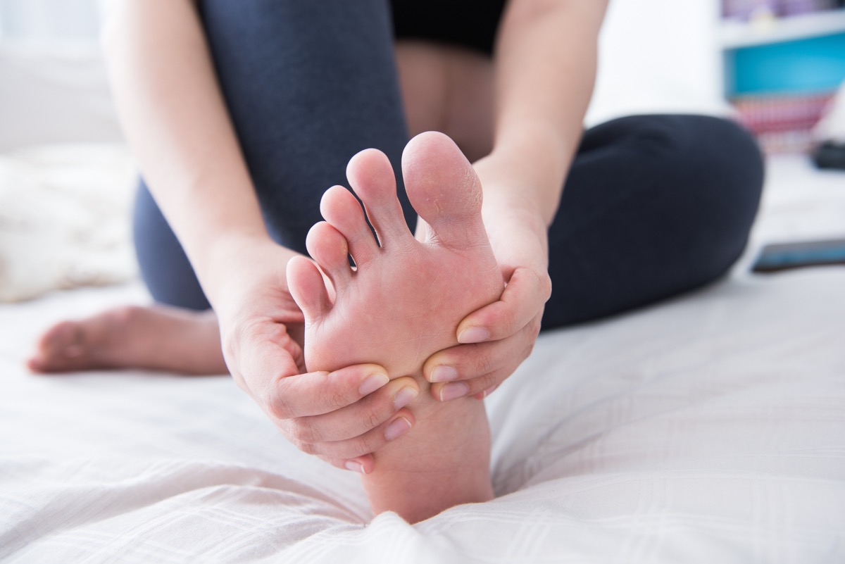 Woman holding feet toes