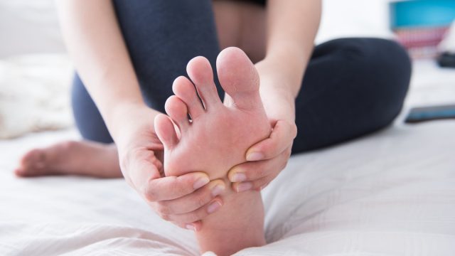 Woman holding feet toes