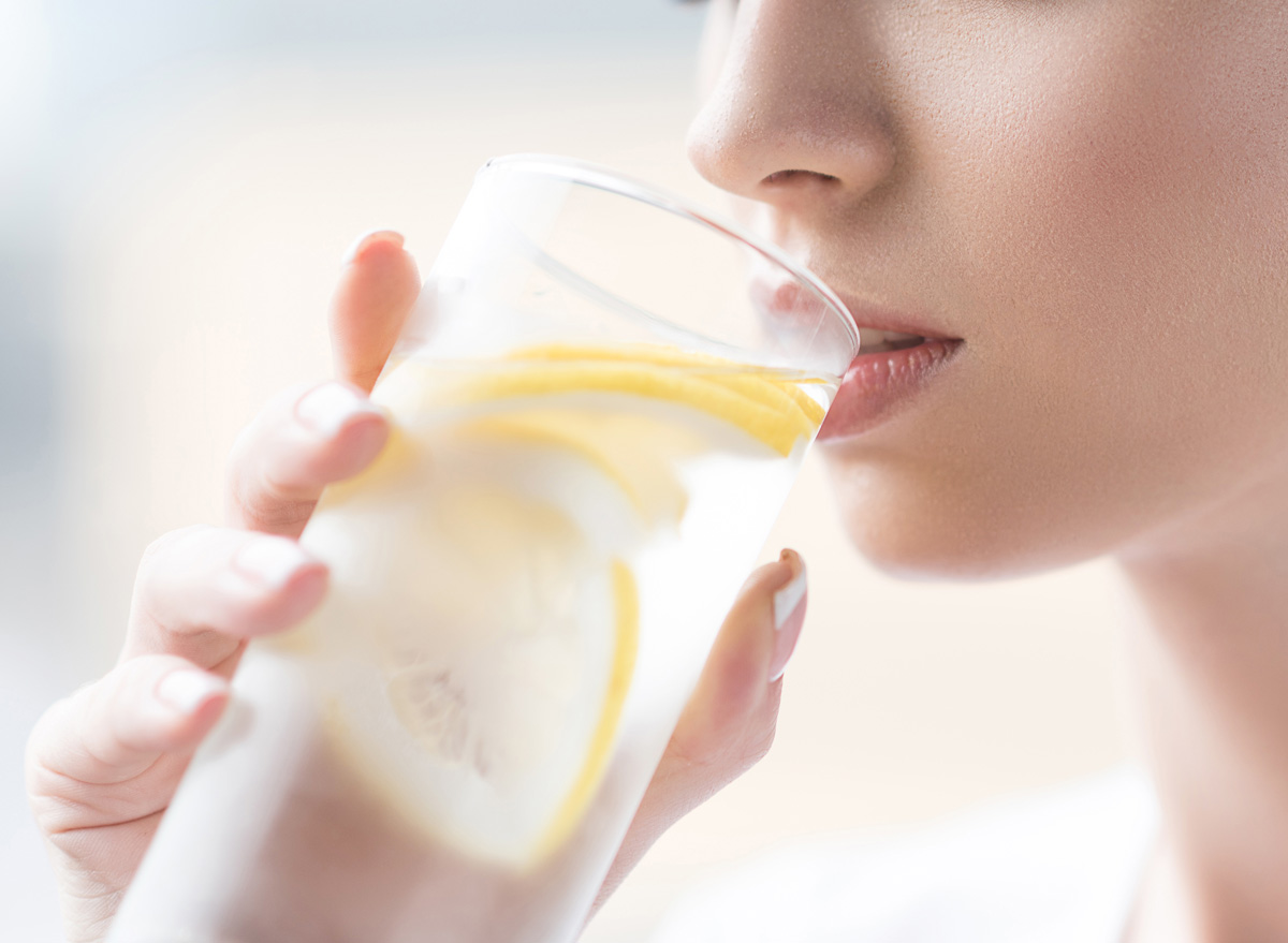 Mulher bebendo água com limão para se hidratar