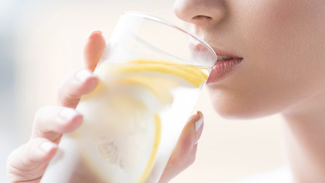 Woman drinking lemon water to be hydrated