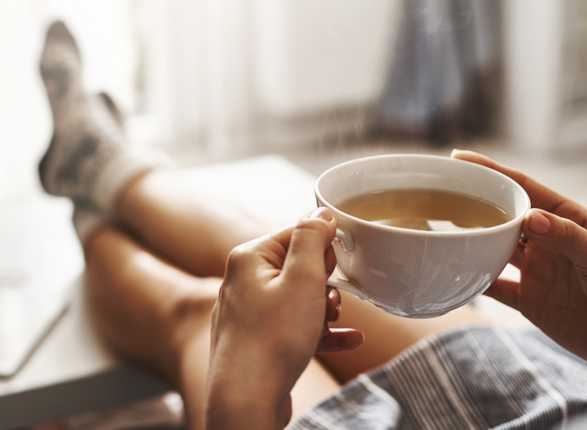 Woman drinking tea relaxing on couch