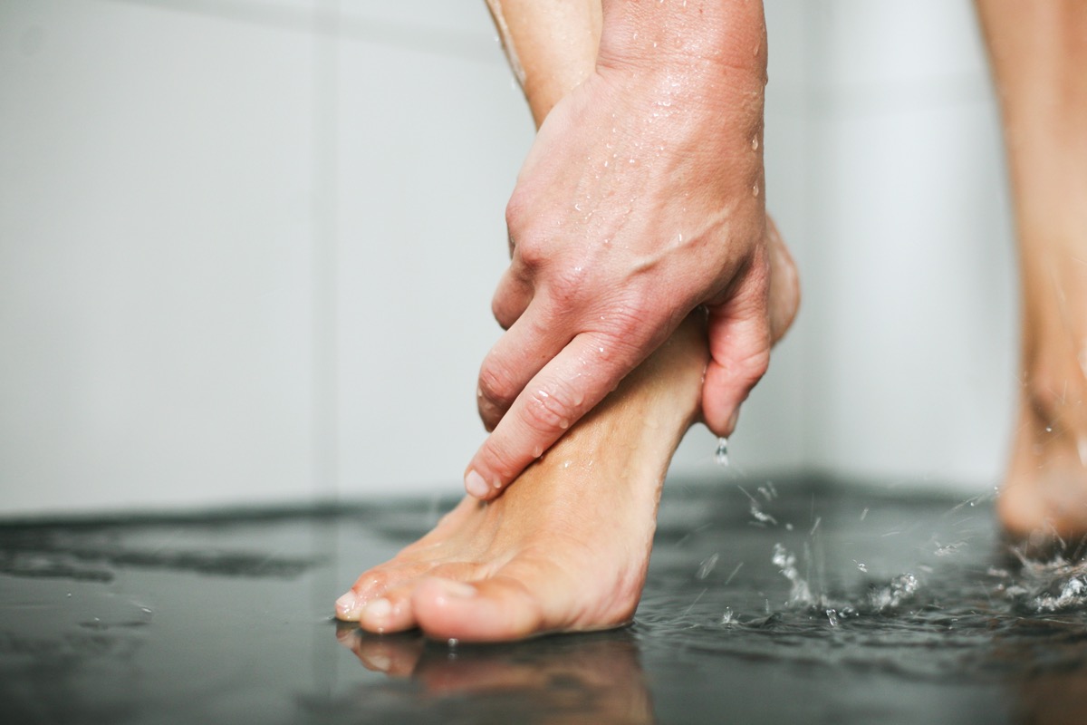 Woman washes her feet in shower