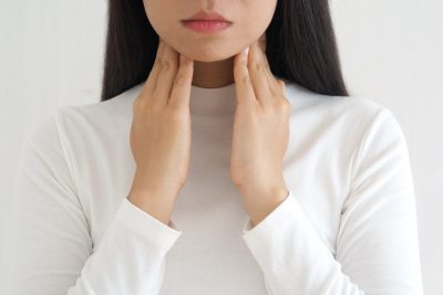 woman touching neck with her hands.