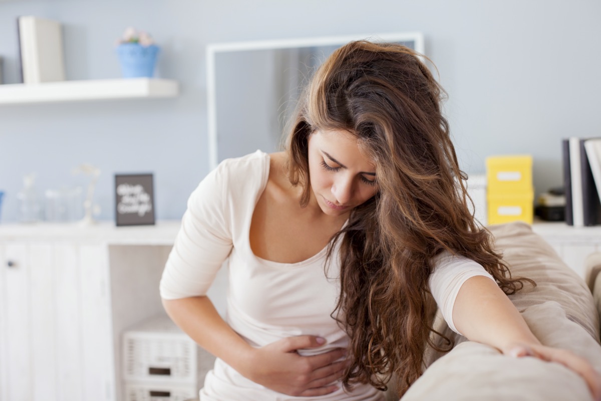 Woman stomach ache abdominal pain sofa