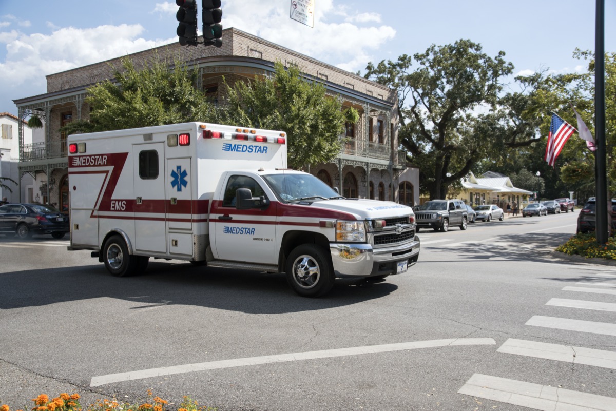 An ambulance on an emergency call driving through the town center of Fairhope