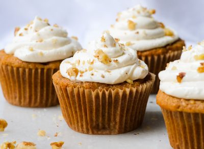 carrot cupcakes with cream cheese frosting and chopped walnuts