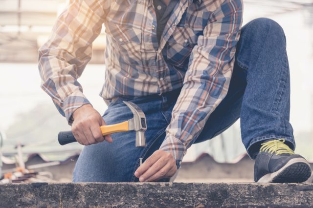 hombre que sostiene un martillo para clavar piso de concreto