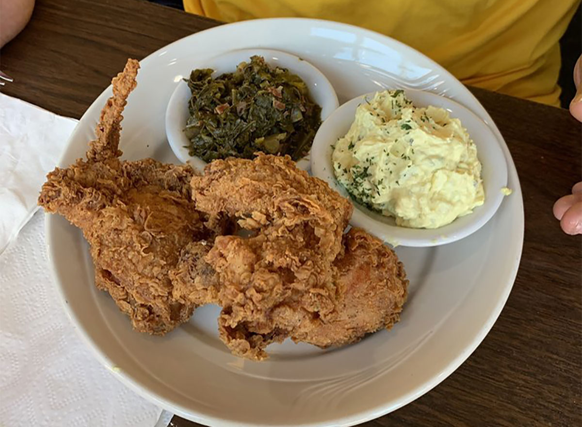 plate of fried chicken with potato salad and collard greens