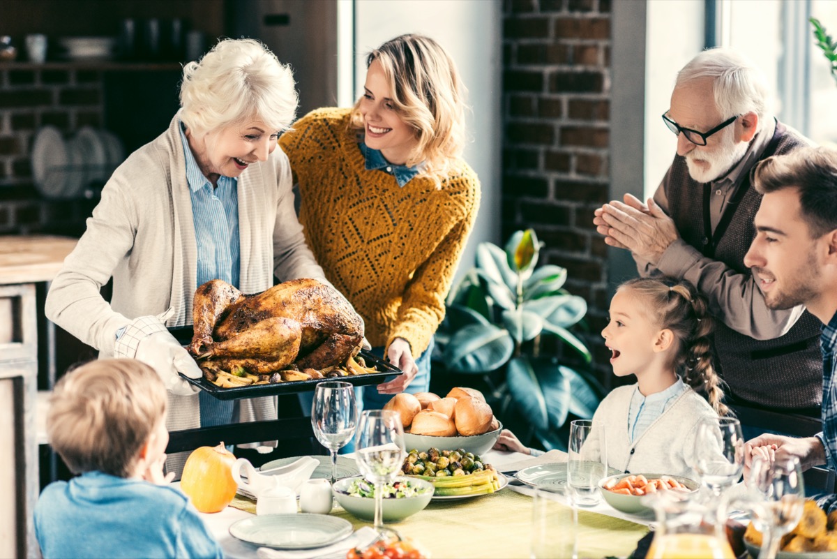 grandmother carrying turkey for family on thanksgiving dinner