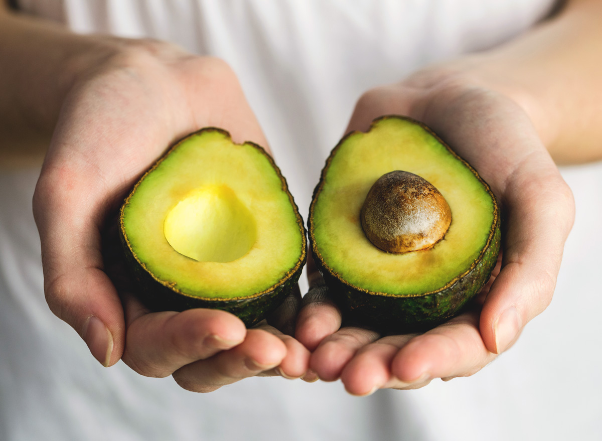 Hold avocado cut open in hand