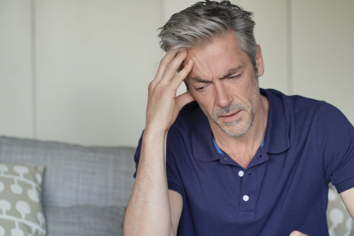 Mature man with bad headache at home