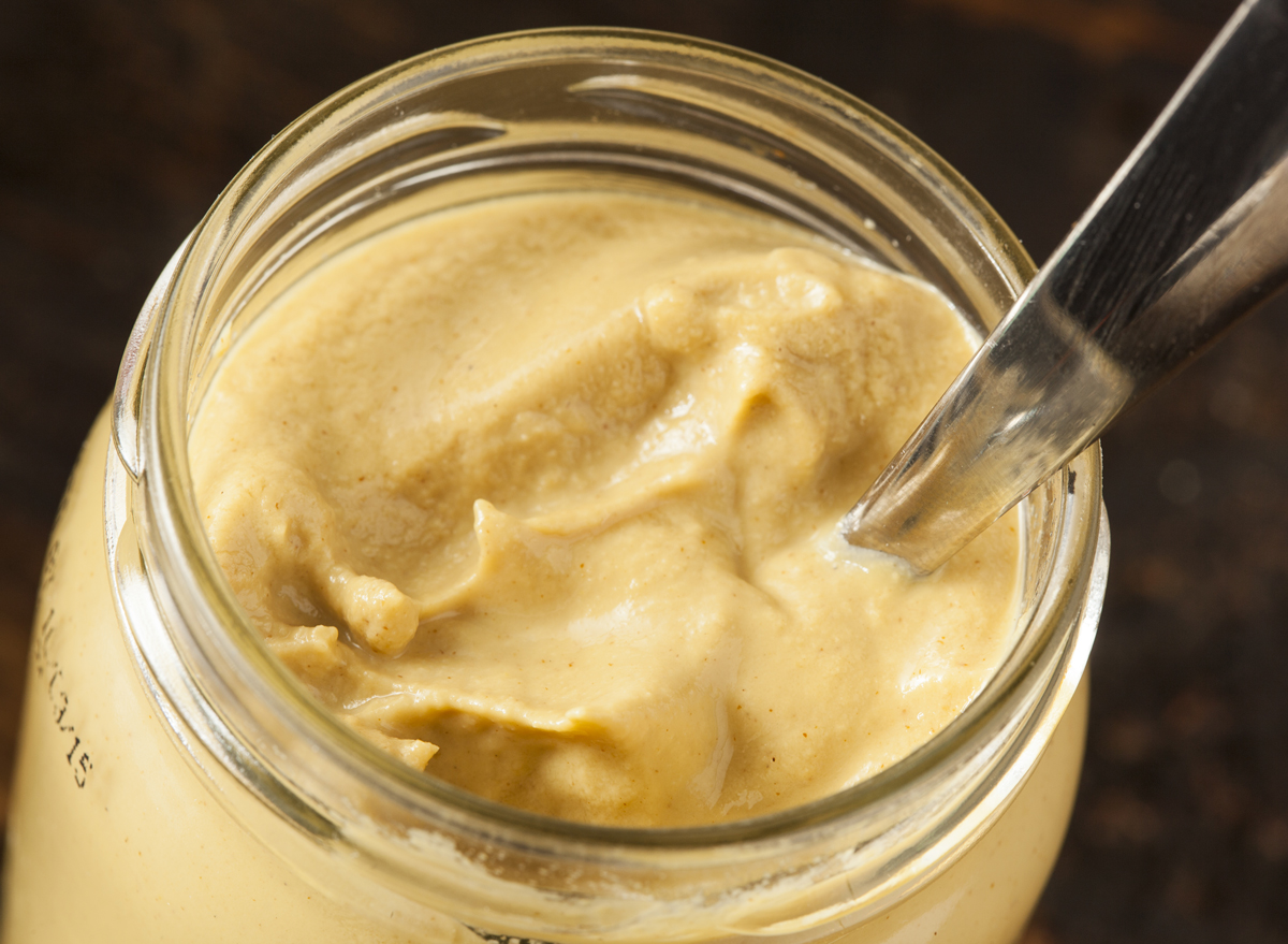 mustard condiment in jar with knife