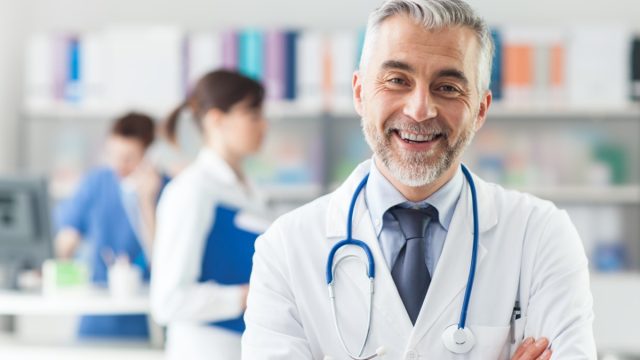 Smiling doctor posing with arms crossed in the office