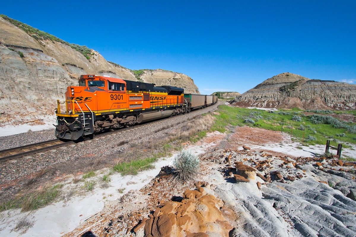 A BNSF Railway locomotive pushes on the rear of an empty coal train in the North Dakota Badlands