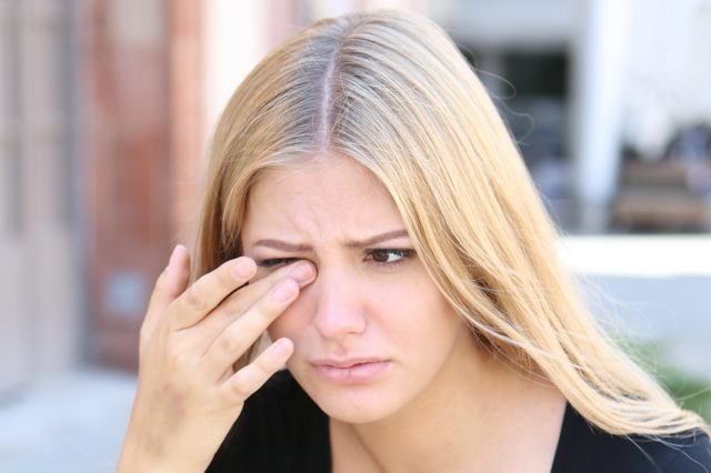 Woman with eye problems outside