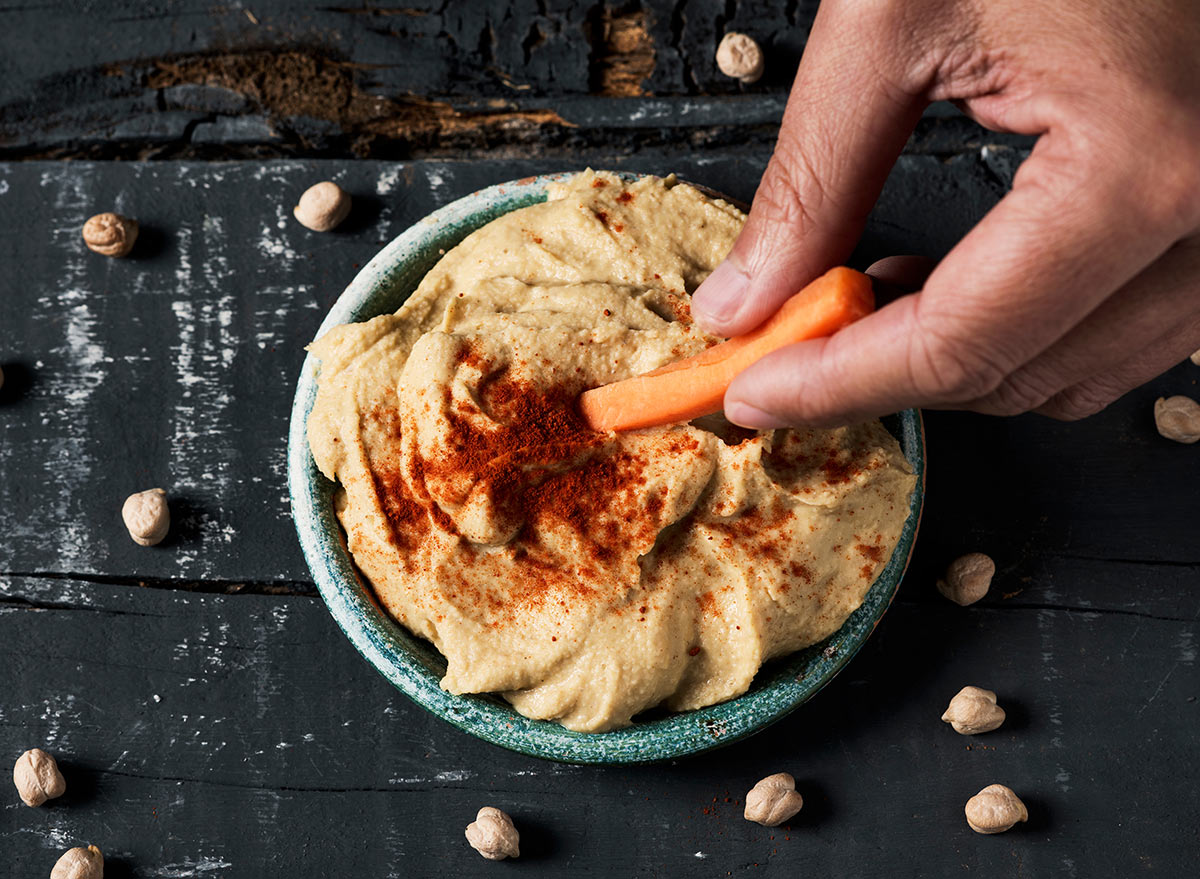 dipping a carrot in homemade hummus