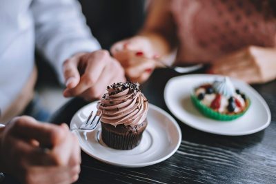 man and woman eating dessert