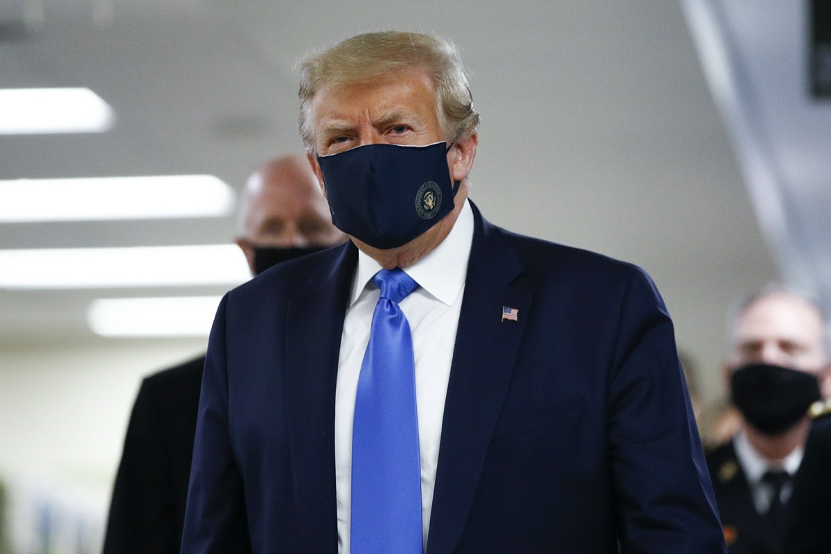 President Donald Trump wears a mask as he walks down the hallway during his visit to Walter Reed National Military Medical Center in Bethesda